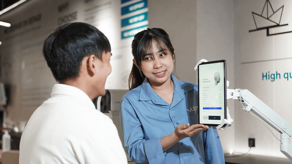 Customer viuum tengah mencoba fitur 3d face scan gratis sembari di dampingi oleh staff handal optik